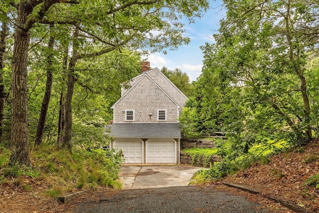 32 Purmackene Ln, Harwich Port, MA 02646 - view of property exterior featuring an attached garage, a chimney, and driveway