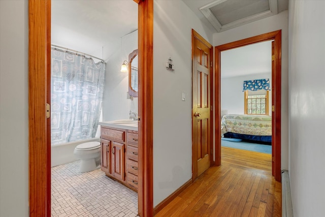 32 Purmackene Ln, Harwich Port, MA 02646 - full bath featuring vanity, shower / bath combo with shower curtain, connected bathroom, a baseboard heating unit, and wood finished floors