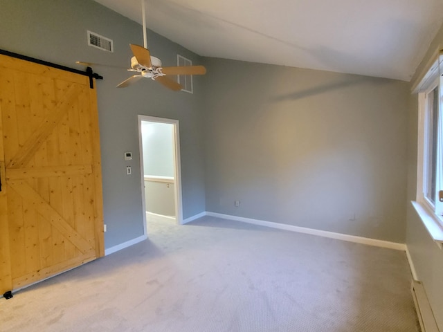 unfurnished room featuring a ceiling fan, visible vents, a barn door, baseboards, and carpet