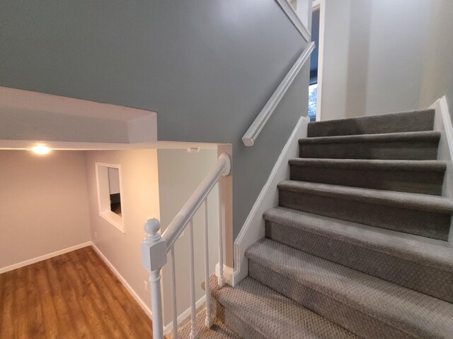staircase with baseboards and wood finished floors