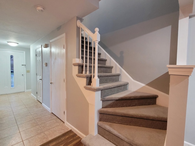 stairway featuring baseboards and tile patterned floors