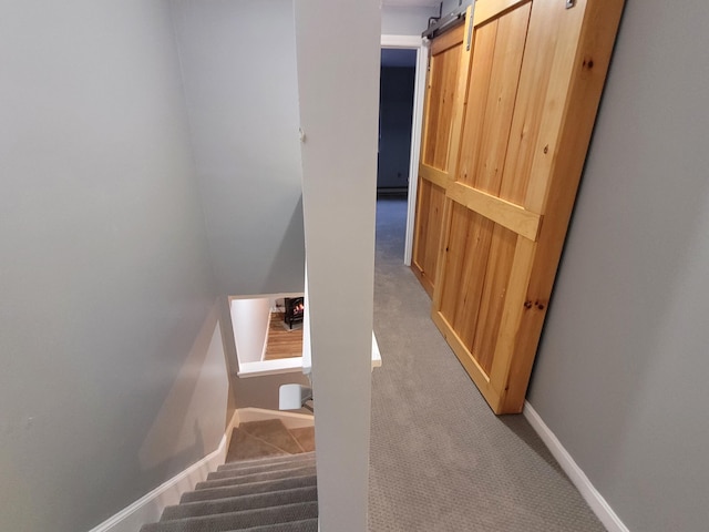 staircase featuring baseboards, carpet, and a barn door