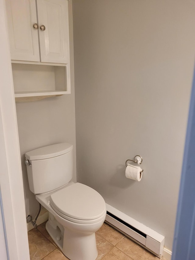 bathroom with baseboards, tile patterned flooring, a baseboard heating unit, and toilet