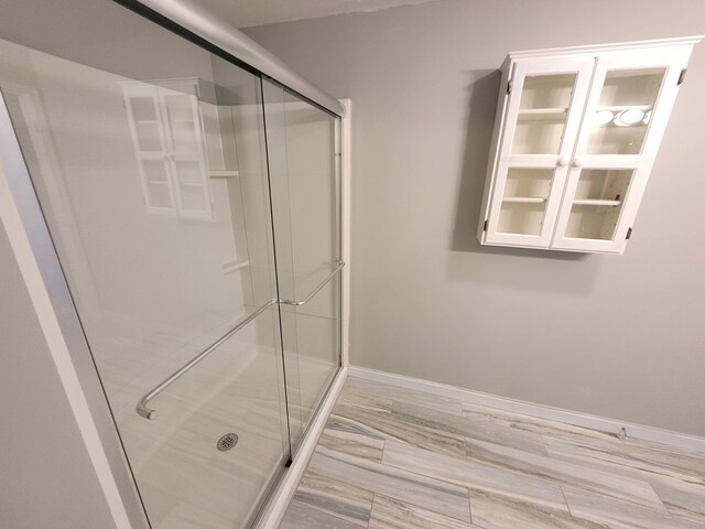 bathroom featuring baseboards and a shower stall