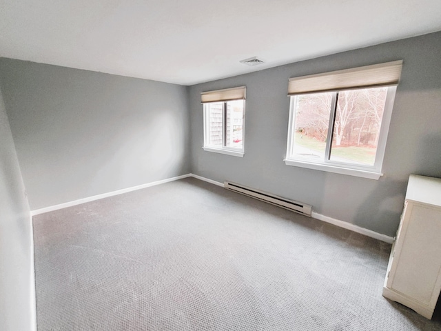 spare room featuring baseboards, a baseboard radiator, carpet flooring, and visible vents