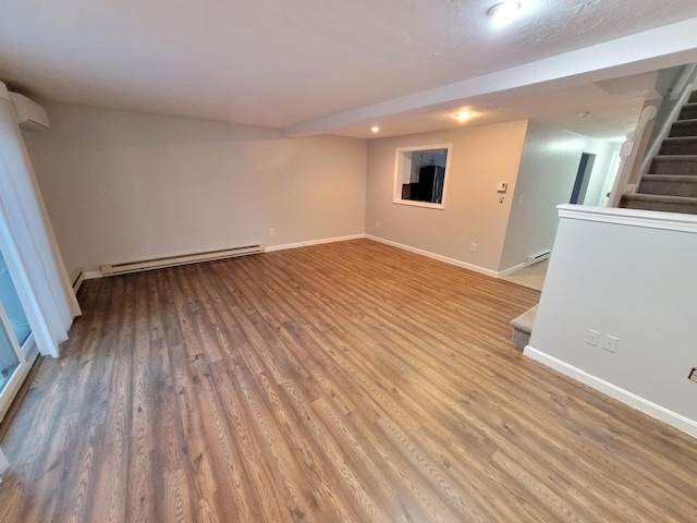 interior space with baseboards, a baseboard heating unit, and light wood-type flooring