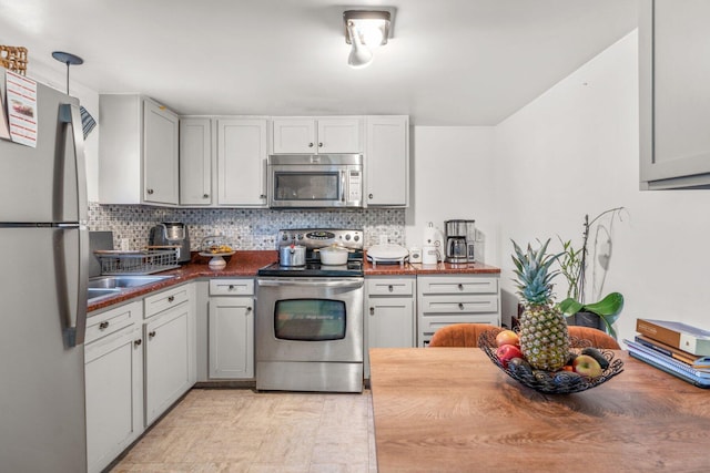 kitchen featuring stainless steel appliances, butcher block counters, and backsplash