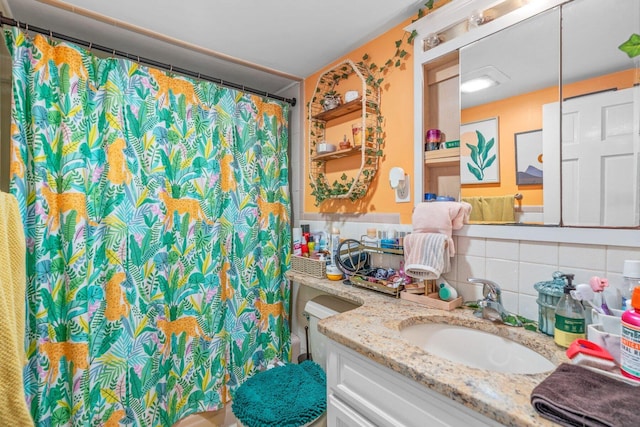 bathroom featuring a shower with shower curtain, backsplash, and vanity