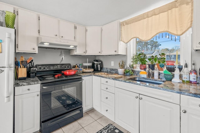 kitchen featuring black range with electric stovetop, freestanding refrigerator, under cabinet range hood, a sink, and light tile patterned flooring