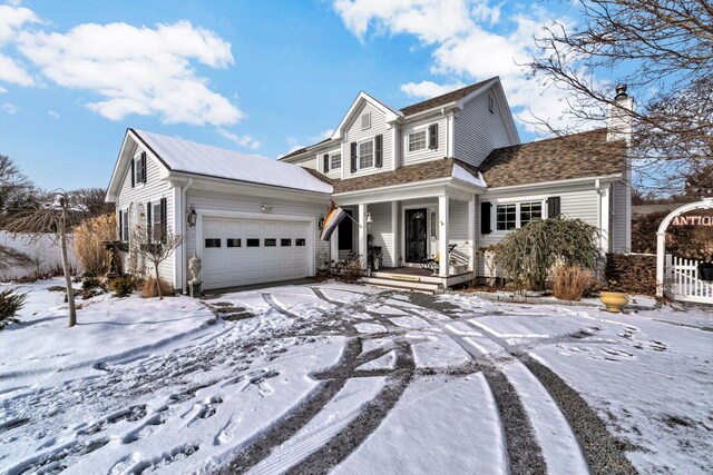 view of front of house with a garage, a chimney, and covered porch