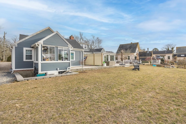 back of property with a lawn and a patio