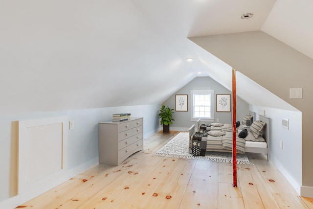 additional living space with light hardwood / wood-style flooring and vaulted ceiling