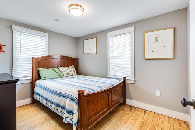 bedroom with light wood-type flooring and multiple windows