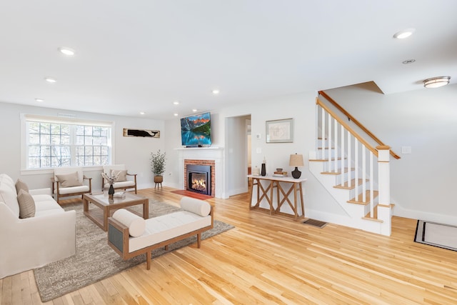 living room featuring a fireplace and light wood-type flooring