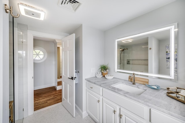 full bathroom with an enclosed shower, vanity, and baseboards