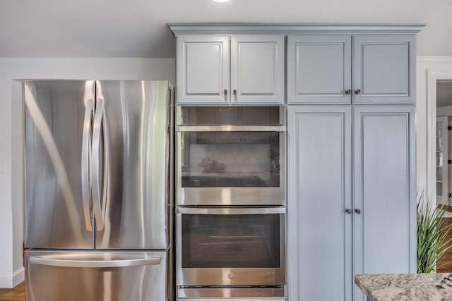 kitchen featuring appliances with stainless steel finishes and light stone counters