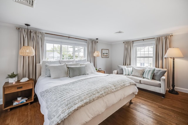 bedroom with multiple windows, crown molding, wood finished floors, and baseboards