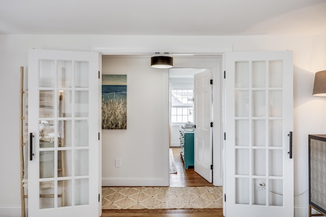corridor with wood finished floors and baseboards