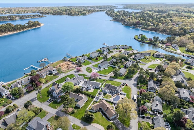 aerial view of property and surrounding area featuring a nearby body of water and nearby suburban area