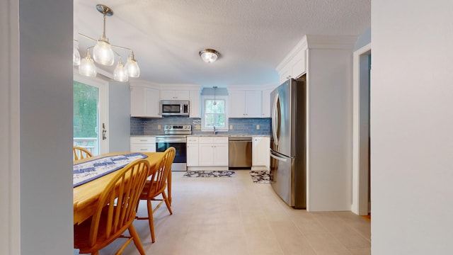 14 Daisy Ln, South Yarmouth, MA 02664 - kitchen featuring stainless steel appliances, white cabinetry, backsplash, light countertops, and a textured ceiling