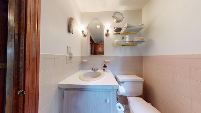 14 Daisy Ln, South Yarmouth, MA 02664 - half bathroom with tile walls, toilet, vanity, and a wainscoted wall