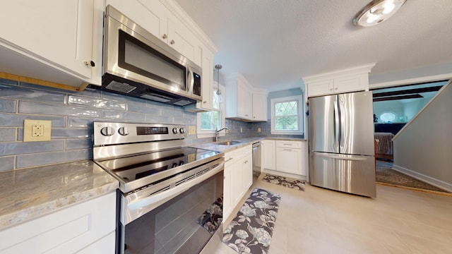 14 Daisy Ln, South Yarmouth, MA 02664 - kitchen with stainless steel appliances, tasteful backsplash, white cabinetry, and a textured ceiling