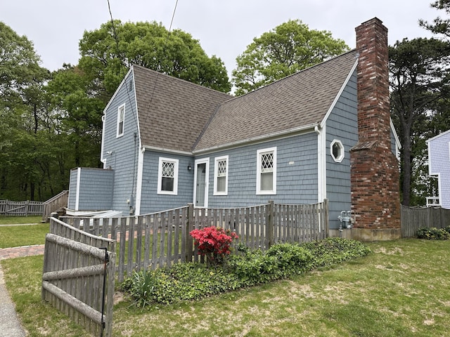14 Daisy Ln, South Yarmouth, MA 02664 - back of property with roof with shingles and a chimney