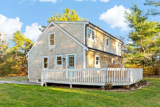 back of property featuring a lawn and a wooden deck