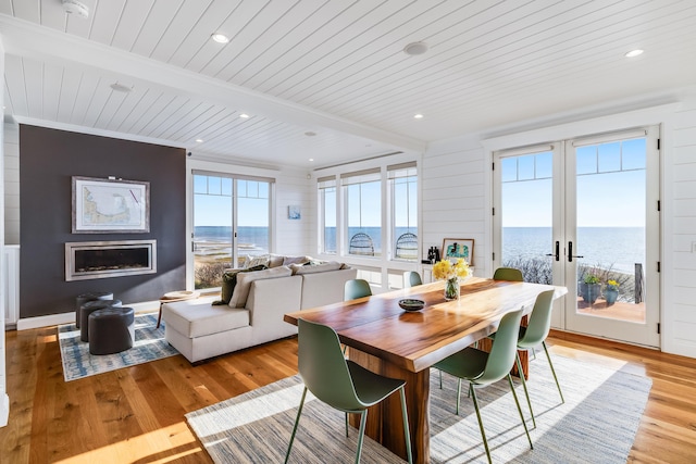 15 W Rd, Eastham, MA 02642 - dining room with a wood ceiling with exposed beams, light wood-style floors, french doors, a fireplace, and a water view