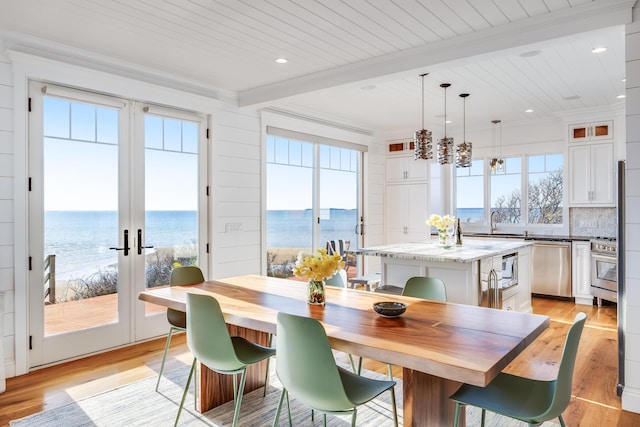 15 W Rd, Eastham, MA 02642 - dining room with beamed ceiling, light wood-style flooring, healthy amount of natural light, a water view, and french doors