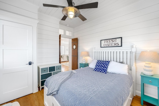 15 W Rd, Eastham, MA 02642 - bedroom featuring wood walls, light wood-type flooring, ornamental molding, and a ceiling fan