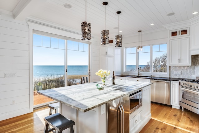 15 W Rd, Eastham, MA 02642 - kitchen featuring appliances with stainless steel finishes, recessed lighting, backsplash, dark stone countertops, and light wood finished floors
