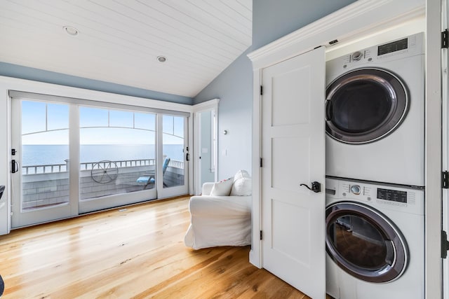 15 W Rd, Eastham, MA 02642 - laundry area featuring stacked washer / dryer, light wood-style flooring, and a water view