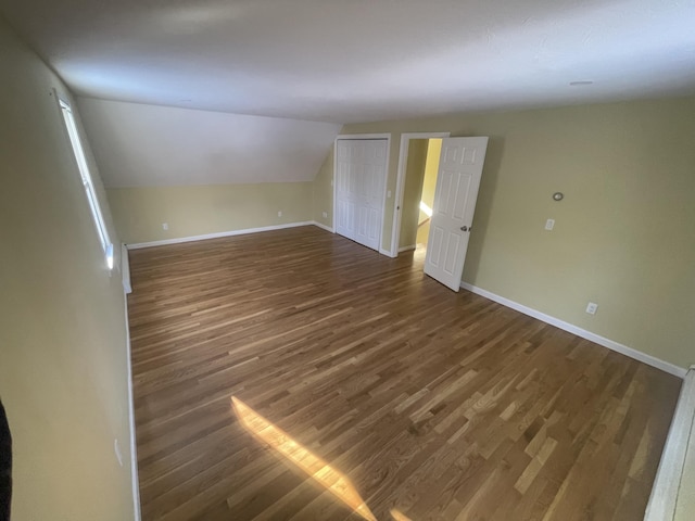 spare room featuring lofted ceiling and dark hardwood / wood-style flooring