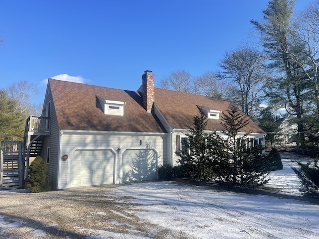 snow covered property with a garage