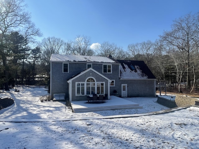 view of snow covered back of property