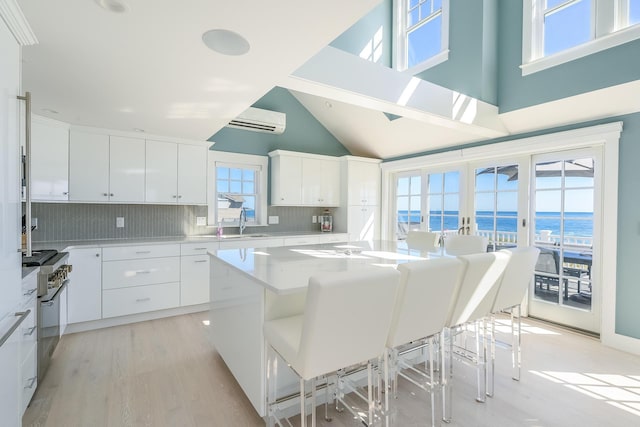 kitchen with a kitchen breakfast bar, white cabinets, and a center island