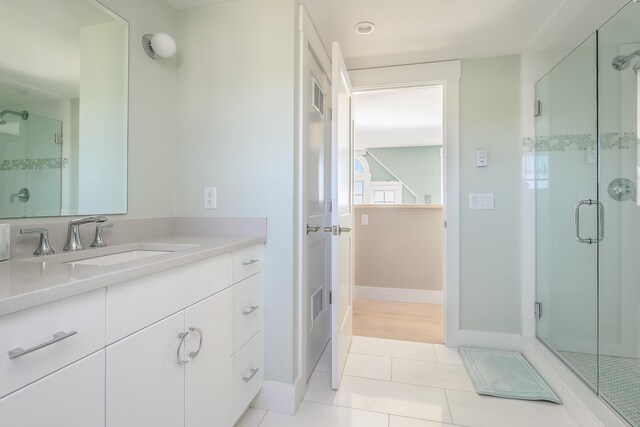 bathroom with vanity, a shower with shower door, and tile patterned floors