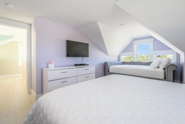 bedroom featuring light hardwood / wood-style flooring and lofted ceiling