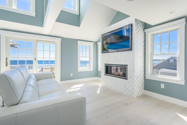 living room featuring vaulted ceiling, light hardwood / wood-style flooring, and a tile fireplace