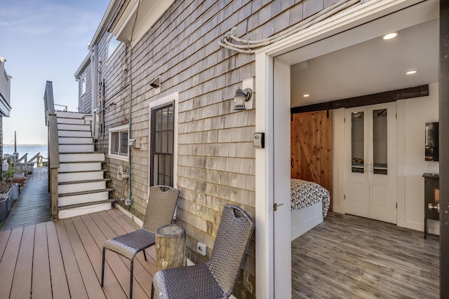 deck with stairway and a water view