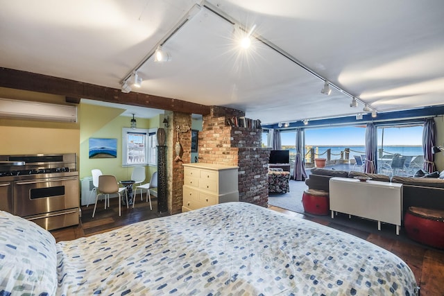 bedroom with track lighting, wood finished floors, and a wall mounted air conditioner