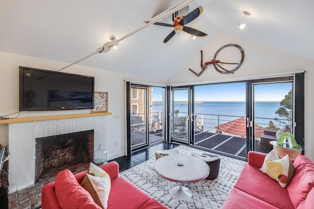 living area with ceiling fan, high vaulted ceiling, a brick fireplace, wood finished floors, and baseboards