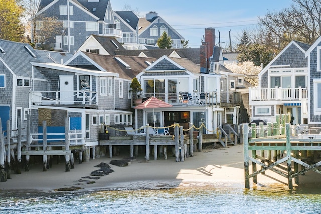rear view of property featuring a water view and a balcony