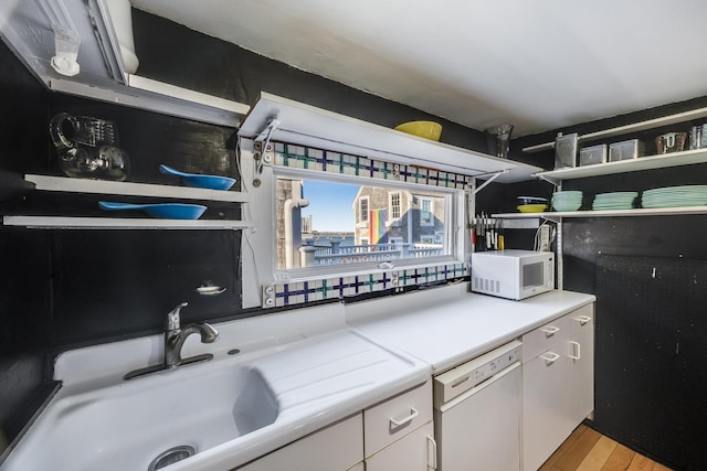 kitchen featuring white appliances, open shelves, white cabinetry, a sink, and light wood-type flooring