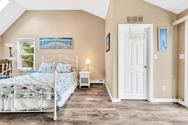 111 School St Unit 6, West Dennis, MA 02670 - bedroom featuring baseboard heating, vaulted ceiling, and wood finished floors