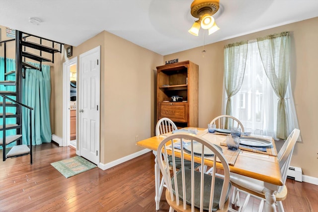 111 School St Unit 6, West Dennis, MA 02670 - dining space with stairway, wood finished floors, a ceiling fan, and baseboard heating