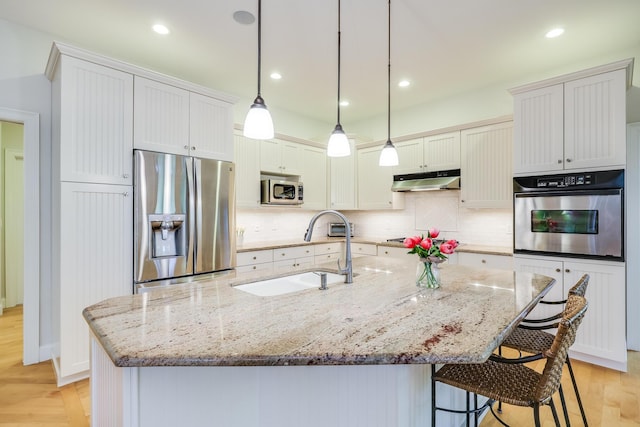 kitchen featuring white cabinetry, an island with sink, stainless steel appliances, and sink