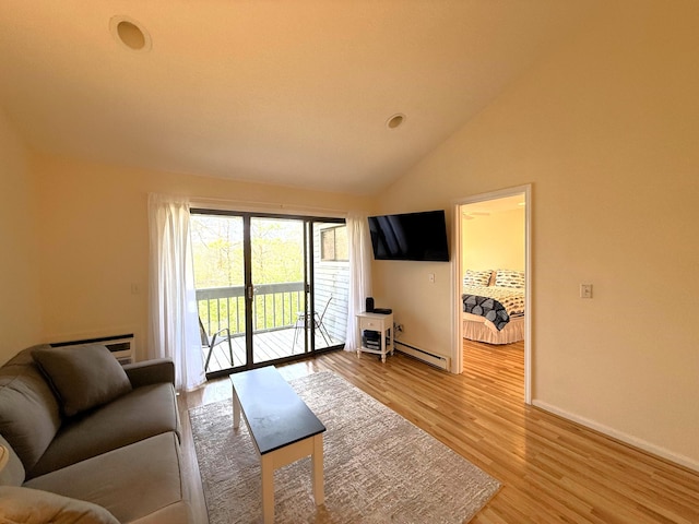 living room featuring a baseboard heating unit, light wood-type flooring, baseboards, a wall mounted air conditioner, and high vaulted ceiling