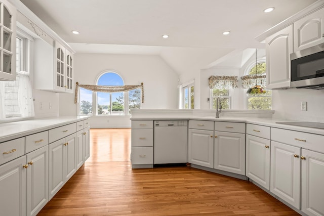 47 Cove View Dr, South Yarmouth, MA 02664 - kitchen with white dishwasher, stainless steel microwave, light wood finished floors, glass insert cabinets, and white cabinetry